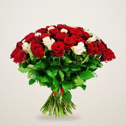 Mixed rose bouquet of red roses with a few white roses tied with a red ribbon
